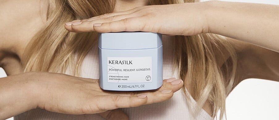 A woman holding a Kerasilk hair mask.